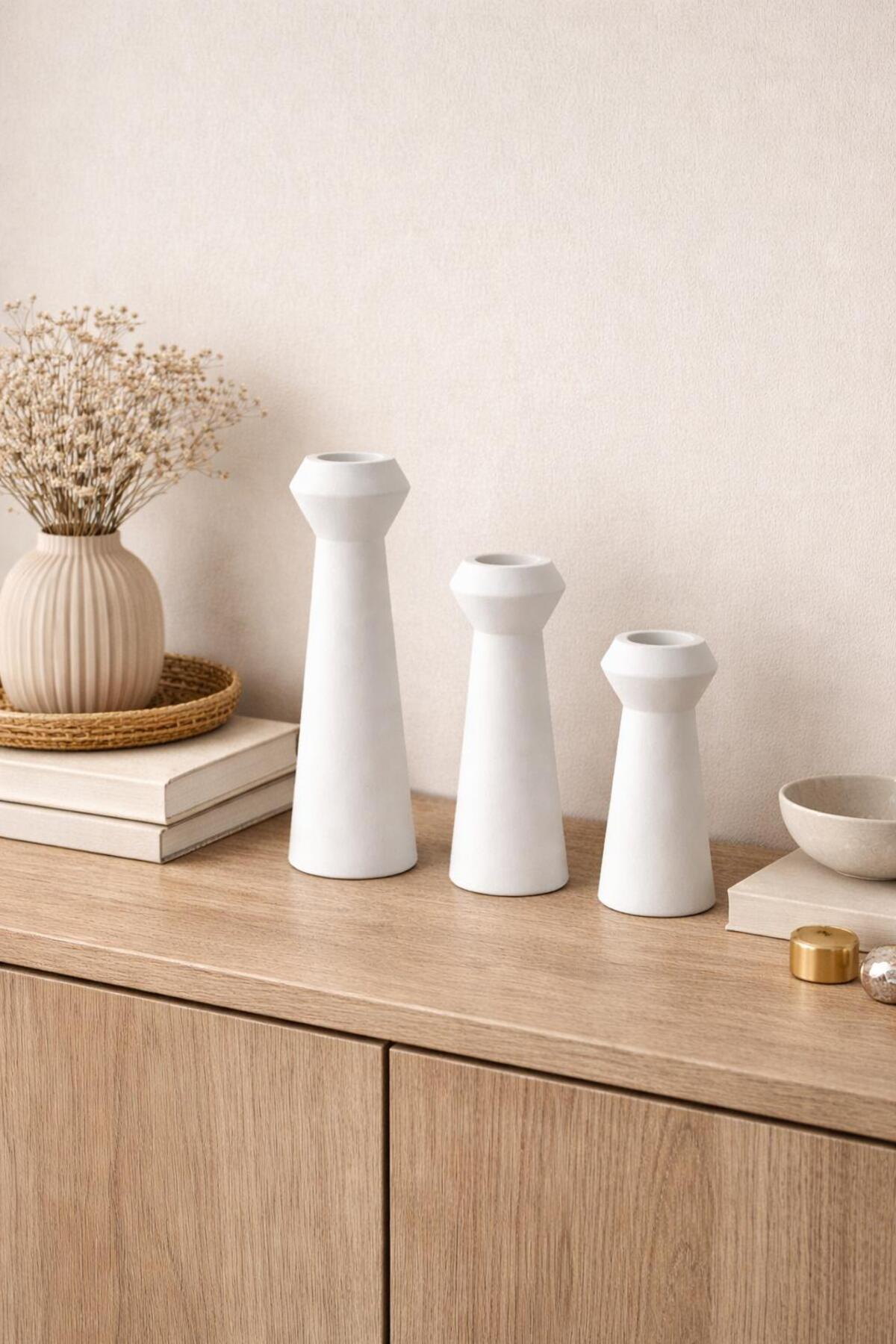 White candle holders on a sideboard